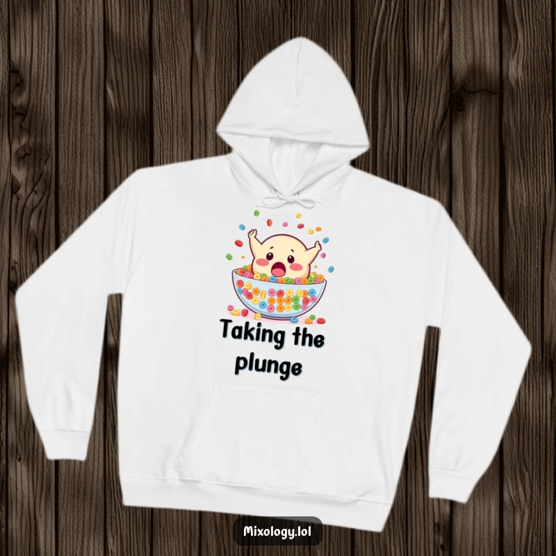Funny hoodie depicting a surprised blob mascot falling headfirst into a large bowl of colorful cereal, offering cozy and humorous style.